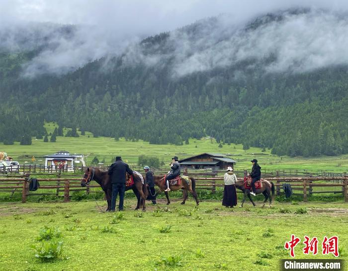 6月10日，游客在魯朗小鎮(zhèn)高山牧場景區(qū)體驗騎馬。　冉文娟 攝