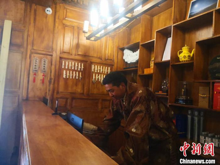 圖為桑杰才讓用電腦處理財務(wù)?！∈缝o靜 攝