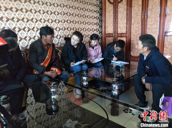 圖為調(diào)查組工作人員正在入戶調(diào)查?！∑钤鲚?攝