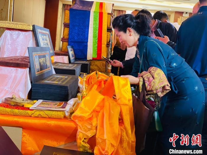 圖為現(xiàn)場藏族民眾向黃金書寫的大藏經(jīng)《甘珠爾》敬獻哈達?！O睿 攝