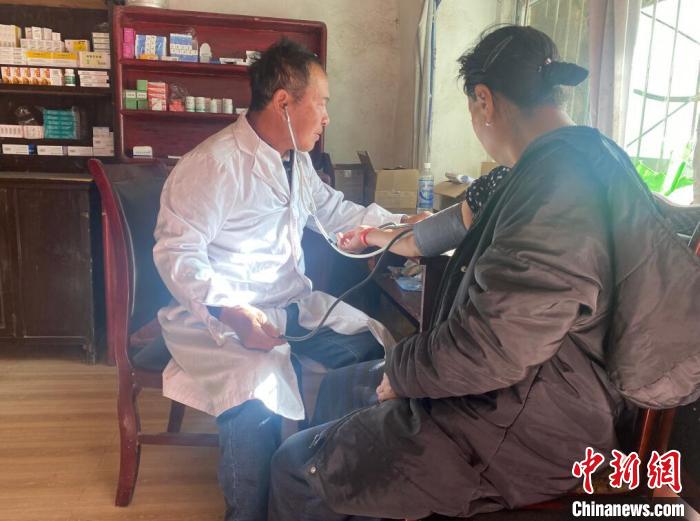 索木滾(左)為村民看病。　壤塘縣委宣傳部供圖