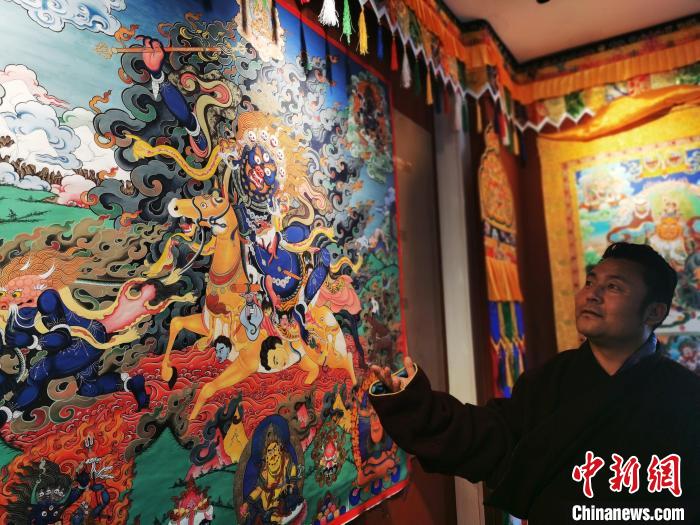圖為久美尖措展示唐卡作品。　張?zhí)砀?攝