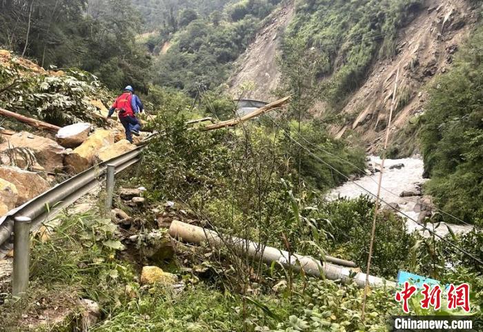 電力搶險人員快速通過危險路段，旁邊是受損的電力線路 四川電力供圖