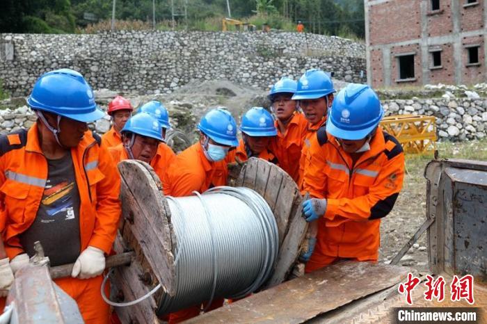 國網(wǎng)四川送變電公司搶險隊員將重達370公斤的鋼絞線搬上車。　劉湘釩 攝