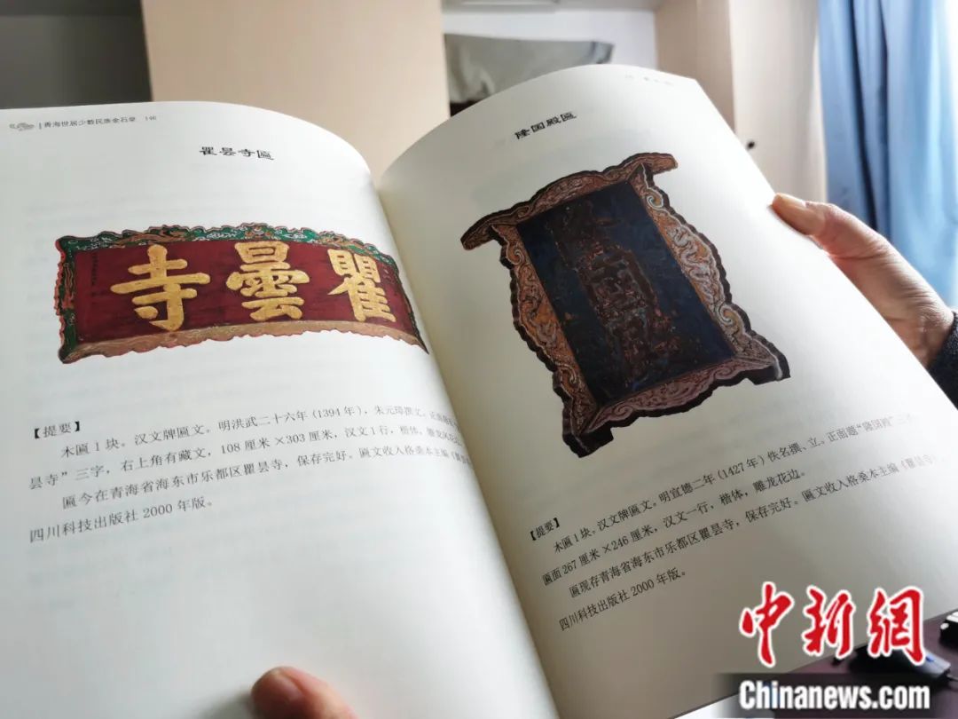 古籍保護(hù)人員展示介紹明代朱元璋撰寫的青海瞿曇寺匾(左)的出版書籍。張?zhí)砀?攝