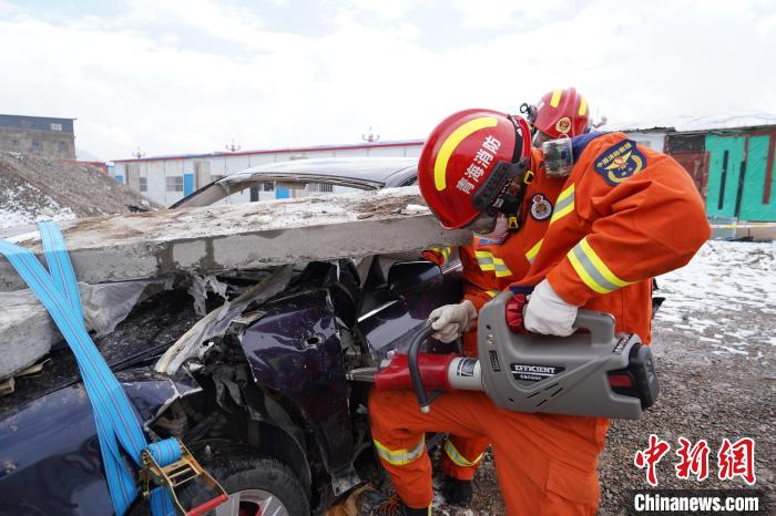 圖為地震實戰(zhàn)拉動現(xiàn)場，參演人員進行車輛破拆?！∮駱湎拦﹫D