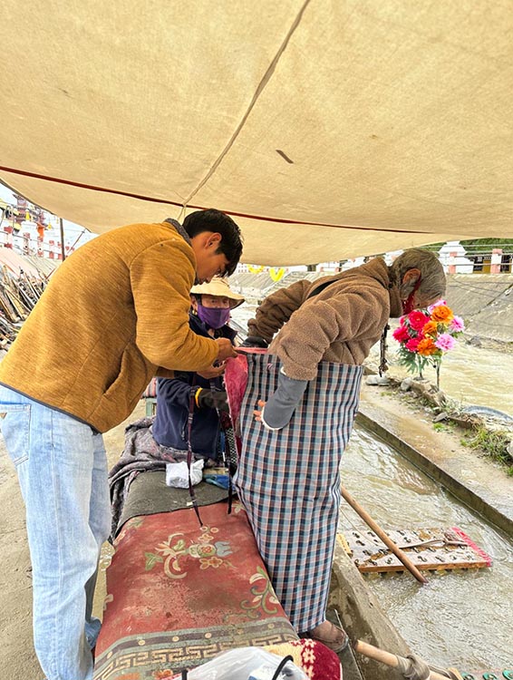 扎西奪爾登為路邊老人送去保暖圍腰。阿壩州文明辦供圖