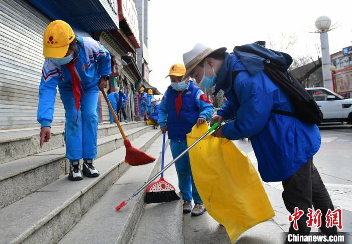圖為拉薩市小學(xué)生打掃街道?！∝暩聛硭?攝