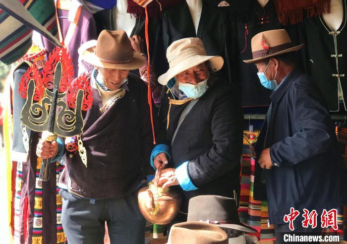 圖為三位藏族老人在集市上聊天交談?！∪轿木?攝