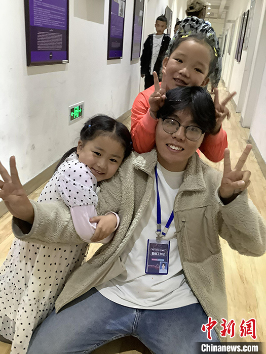 “Z世代”旦真旺加認為，拉薩是一座開放與包容的城市，記憶中的拉薩是彩色的。2021年，旦真旺加從浙江大學漢語言文學專業(yè)畢業(yè)后，他選擇回到拉薩，成為一名漢語文實習助教。圖為8月4日，旦真旺加在課間陪學生玩耍。 <a target='_blank' ><p  align=