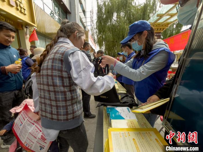 圖為志愿者為市民發(fā)放網絡安全宣傳手冊?！≈x牧 攝