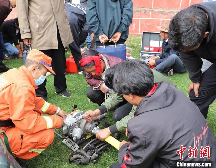 圖為森林消防員為護林員講解滅火裝備的使用方法?！〔际猩窒乐ш?供圖