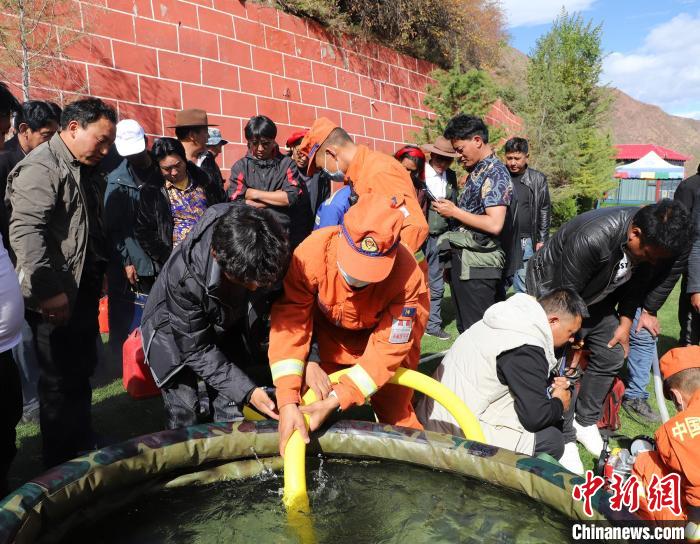 圖為森林消防員為護林員講解滅火裝備的使用方法?！〔际猩窒乐ш?供圖