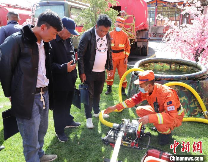 圖為森林消防員為護林員講解滅火裝備的使用方法?！〔际猩窒乐ш?供圖