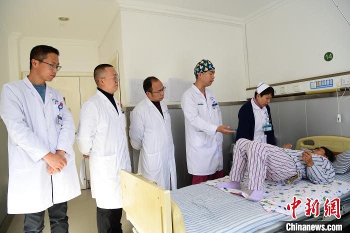 圖為何蔚副主任醫(yī)師(站右二)及團隊術(shù)后指導患者進行腰背肌鍛煉?！∝暩聛硭?攝