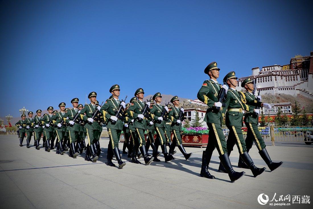 國旗護(hù)衛(wèi)隊(duì)隊(duì)員緊握鋼槍，踏著威武雄壯的步伐，走向國旗臺。人民網(wǎng) 次仁羅布攝