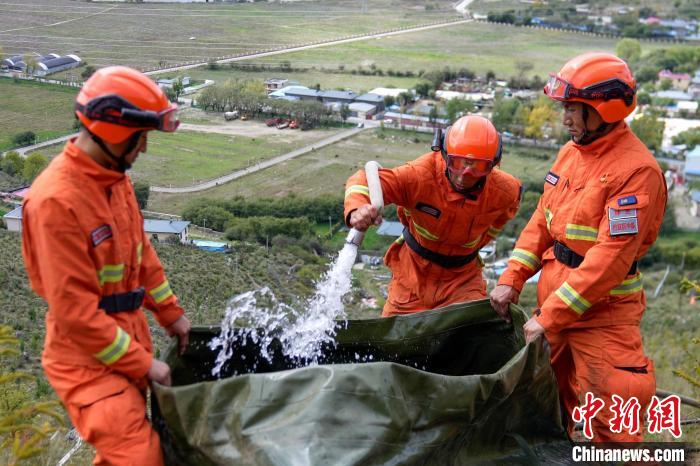 技能大練兵過(guò)程中，消防員在陡坡上向蓄水池注水?！±顕?guó)燾 攝