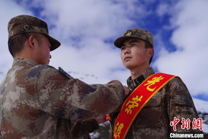 排長王朝偉(圖左)給退伍老兵佩戴大紅花?！∥鞑厣侥宪姺謪^(qū)某團供圖