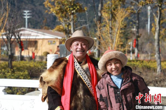 圖為林芝市巴宜區(qū)布久鄉(xiāng)仲果村村民桑杰與孫子一起參加藏歷新年活動(dòng)?！埩?攝