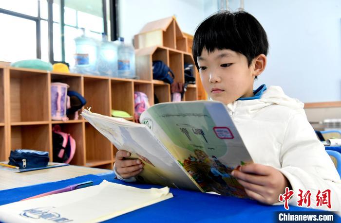 3月14日，西藏拉薩市第一小學(xué)一年級(jí)六班學(xué)生丁增樂(lè)吉在閱讀藏語(yǔ)課本。　李林 攝
