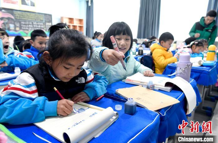 3月14日，西藏拉薩市第一小學(xué)一年級(jí)六班學(xué)生白瑪朗珍(圖左)在藏語(yǔ)文課上書(shū)寫藏文。　李林 攝