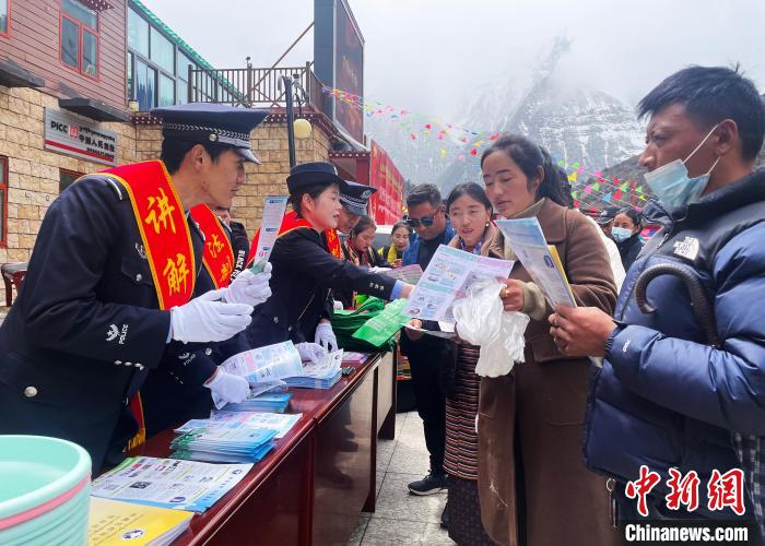 圖為山南玉麥邊境派出所民警為轄區(qū)群眾發(fā)放法律知識(shí)宣傳單?！＄婗?　攝