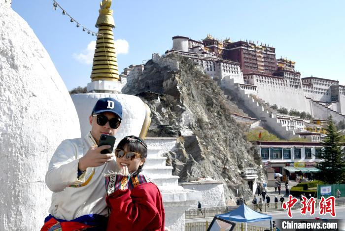 4月17日，游客身著藏式元素服裝在拉薩布達(dá)拉宮觀景臺(tái)拍照留念。　李林 攝