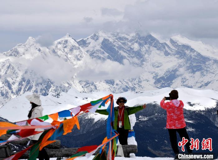 圖為5月14日，西藏林芝色季拉山觀景臺，游客與南迦巴瓦峰合影。　李林 攝