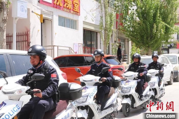 民警騎著電瓶車在轄區(qū)巡邏走訪。　黃創(chuàng)偉 攝