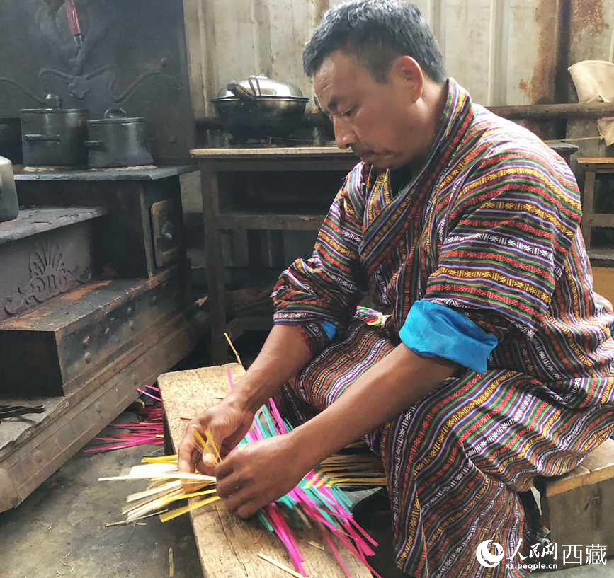 門巴族漢子愛明正在編織藤竹品。