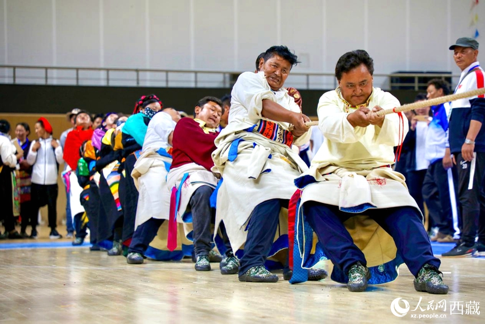 身著民族服裝的農(nóng)牧民選手在拔河比賽現(xiàn)場。